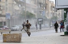 A member of the Libyan army runs with a weapon during clashes between members of Islamist militant group Ansar al-Sharia and a Libyan army special forces unit in Ras Obeida